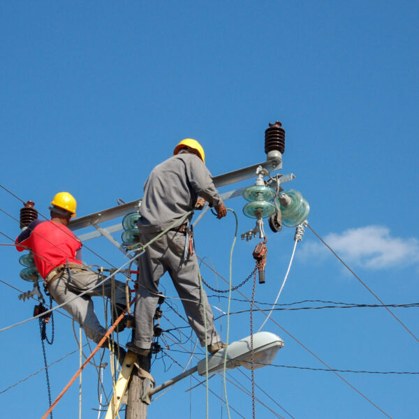 A low angle shot of electric linemen working on pole